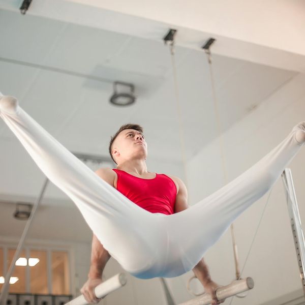 Man performing a controlled strength exercise in a modern, minimalist gym.